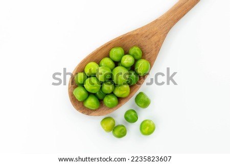 green peas isolated. fresh organic vegetables. on a wooden spoon. top view