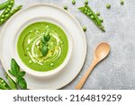 Green peas soup. Healthy vegan green peas soup served in bowl on rustic table.