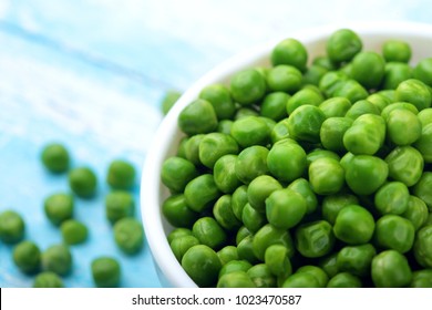 Green peas.In white bowl.On cyan blue wooden rustic table.Top view .Copy space.Selective focus