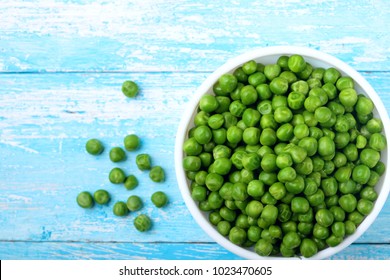 Green peas.In white bowl.On cyan blue wooden rustic table.Top view .Copy space