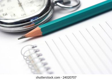 green pen,chronometer and notebook close up shallow DOF