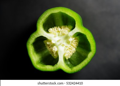 Green Pepper Cut In Half With Top View On Black Background