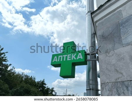 A green pharmacy cross with Cyrillic script 