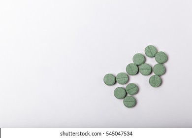 Green pills on white background