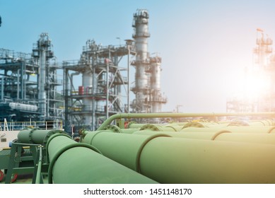 Green Pipe line in Oil and gas industrial, Oil refinery plant from industry, Refinery Oil storage tank and pipe line steel with blue sky and white clouds background.