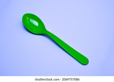 Green plastic spoon white background 