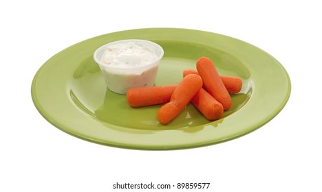 A Green Plate With Several Baby Carrots And Ranch Dressing On A White Background.