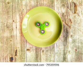 Green Plate With Spinner On Wooden Background, Toned