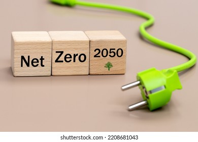 Green plug with a cable, and wooden blocks with the words Net zero 2050, Environmental concept, modern Energy generation, elimination of co2, zero carbon footprint, reduction of pollution - Shutterstock ID 2208681043