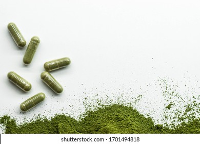 Green powder with green capsules on white background.