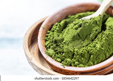 Green powder chlorella, spirulina on gray concrete background. Concept dieting, detox, healthy superfood, which contains protein. Copy space.