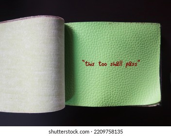 Green PU material sample with handwritten red text THIS TOO SHALL PASS, self reminder mantra that nothing, good or bad, lasts forever - all circumstances are temporary - Shutterstock ID 2209758135