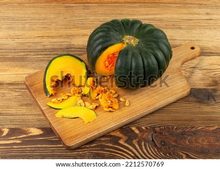 Green pumpkin cut on wood table, sweet kabocha round squash, whole acorn pumpkin on rustic background