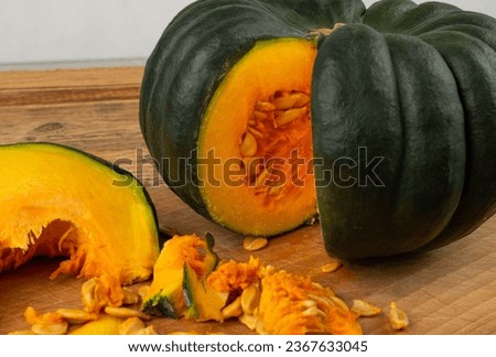 Green pumpkin cut on wood table, sweet kabocha round squash, whole acorn pumpkin on rustic background closeup