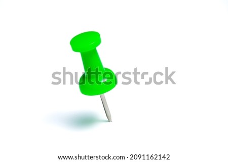 Green push pin or thumbtack isolated on a white background.