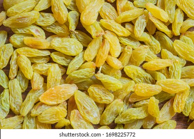Green raisins spread on kitchen counter. Green raisin background.