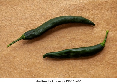 Green Raw Fresh Unripe Pasilla Heirloom Pepperson Brown Paper Table. Top View.