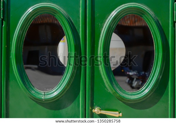 Green rear\
doors with oval windows of an old\
car\
