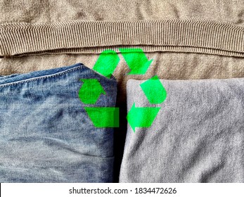 Green recycling icon on neat old clothes, ecological and sustainable development background, recycle reuse waste clothes materials, abstract carbon Free concept, environment friendly wallpaper