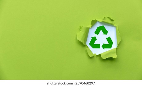 Símbolo de reciclagem verde no plano de fundo do papel rasgado