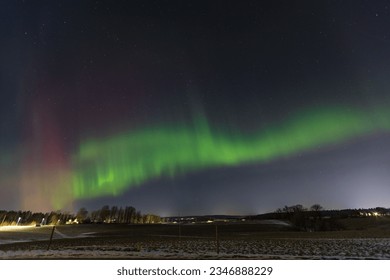 Green and red aurora borealis dancing on the sky, polar lights