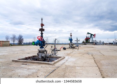 Green And Red Pumpjack, Oil Horse, Oil Derrick Pumping Oil Well With Dramatic Cloudy Sky Background