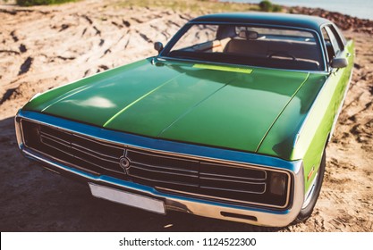 Green retro car is standing on the beach. Vintage classic car. Old and stylish. Muscle car.