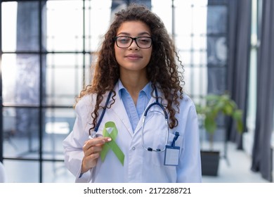 Green Ribbon In Doctor Hand As A Symbol To Awareness Lymphoma Cancer.