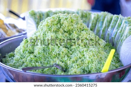 Green rice flakes (Com in Vietnamese). Com is freshly harvested sticky sweet rice and is pounded and mixed with shredded fresh coconut rice. Delicious and nutritious street food