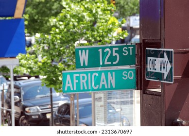 green road signs at the intersection of West 125th Street and African Square in Harlem, New York City