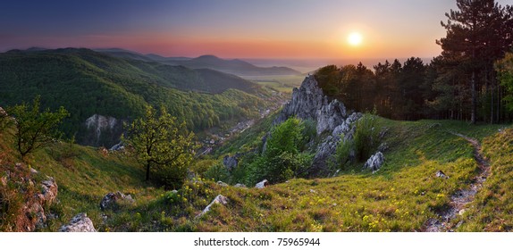 Green Rocky Moutain At Sunset Wih Path And Sun.