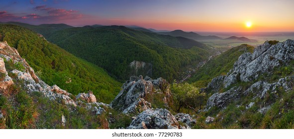 Green Rocky Moutain At Sunset Wih Path And Sun.