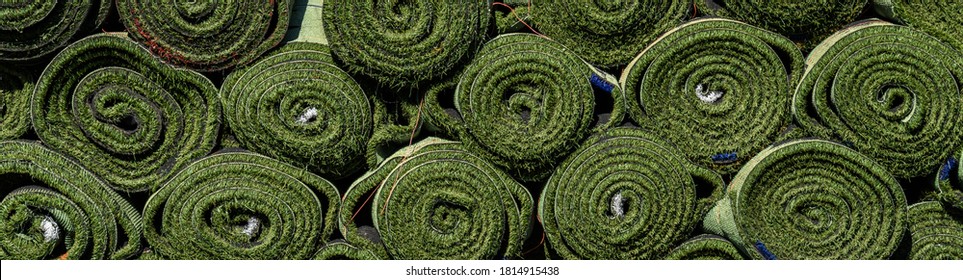 Green Rolls Of New Artificial Turf Ready For Installation On An Outdoor Sports Field
