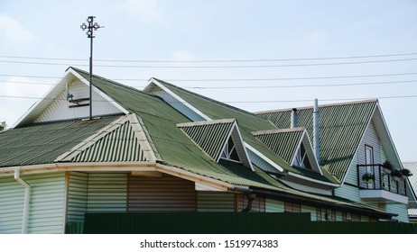 Green Roof Coating. Stock Footage. Beautiful Green Roof Is Made Of Profiled Flooring. New Roof Covering Of Country House. Multi-pitched Roof With Windows On Sides