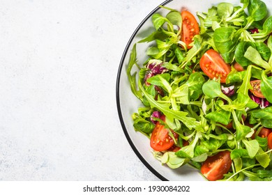 Green Salad With Arugula, Lamb And Tomatoes. Healthy Vegan Dish. Top View At White Table.