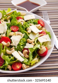 Green Salad With Brie, Cashew And Cherry Tomatoes. Dressing On Background