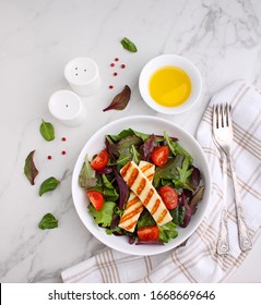 Green Salad With Fried Halloumi Cheese In A White Plate On A Marble Background, Top View. Copy Space