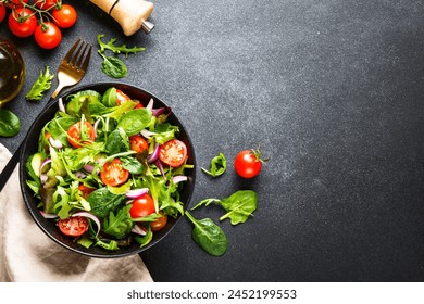 Green Salad with salad leaves and vegetables at black background. - Powered by Shutterstock