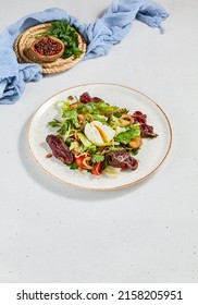 Green salad with sliced roast beef and pachot egg. Roast beef salad with vegetables and egg on concrete background in minimal style. Aesthetic composition with meat salad, textile and spices