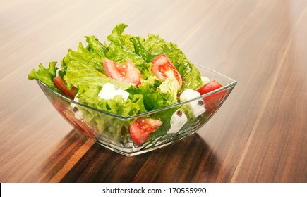 Green Salat In A Bowl On Desk. Tomato, Cheese And Salad