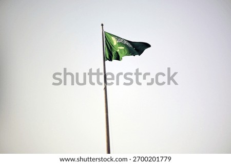 Green Saudi flag flapping gently in the wind symbolizes national pride and identity. Ideal for travel, culture, or patriotic campaigns.