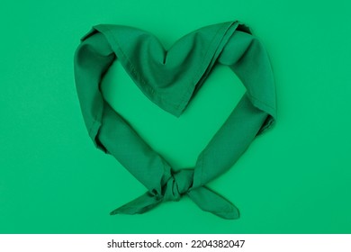 Green scarf on a green background in the shape of a heart for September 28, legal and safe abortion. High quality photo