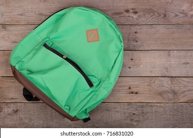 Green School Backpack On Brown Wooden Table. Top View