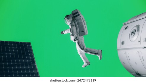 Green Screen Chroma Key Studio Production: Male Astronaut in a Costume in Outer Space. Trained Professional Spaceman Performing Extravehicular Activity Next to a Satellite and Solar Panels - Powered by Shutterstock