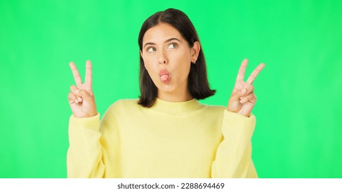 Green screen, funny face expression and happy woman posing with tongue out, peace sign and carefree personality. Portrait, female model and smile in studio with emoji reactions, meme and happiness - Powered by Shutterstock