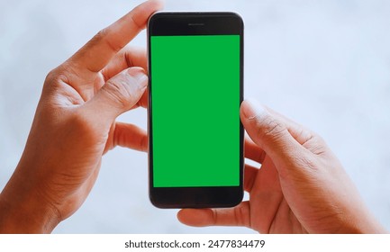 Green screen Smart phone screen, Hand-held smartphone with green screen, ideal for digital mockups, against a blurred background. - Powered by Shutterstock