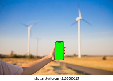 Green Screen Smartphone On The Windmills Background. Chroma Key. Windmills Green Energy