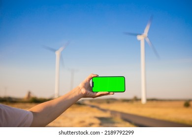 Green Screen Smartphone On The Windmills Background. Chroma Key. Windmills Green Energy