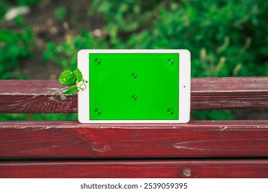 Green Screen Tablet on a Red Wooden Bench Outdoors. Green screen mockup - Powered by Shutterstock