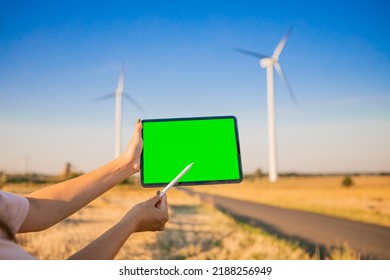 Green Screen Tablet On The Windmills Background. Chroma Key. Windmills Green Energy